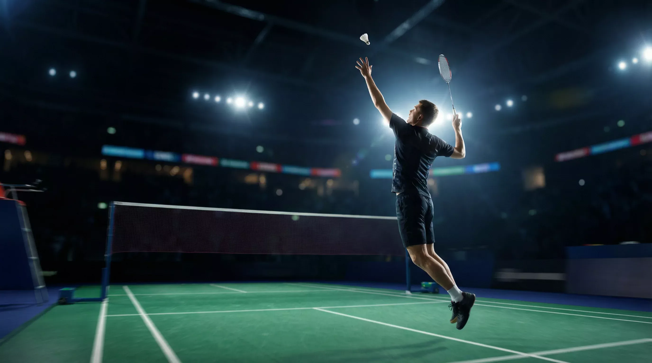 Badminton-Spieler beim Smash während eines Live-Wettkampfs in einer beleuchteten Halle