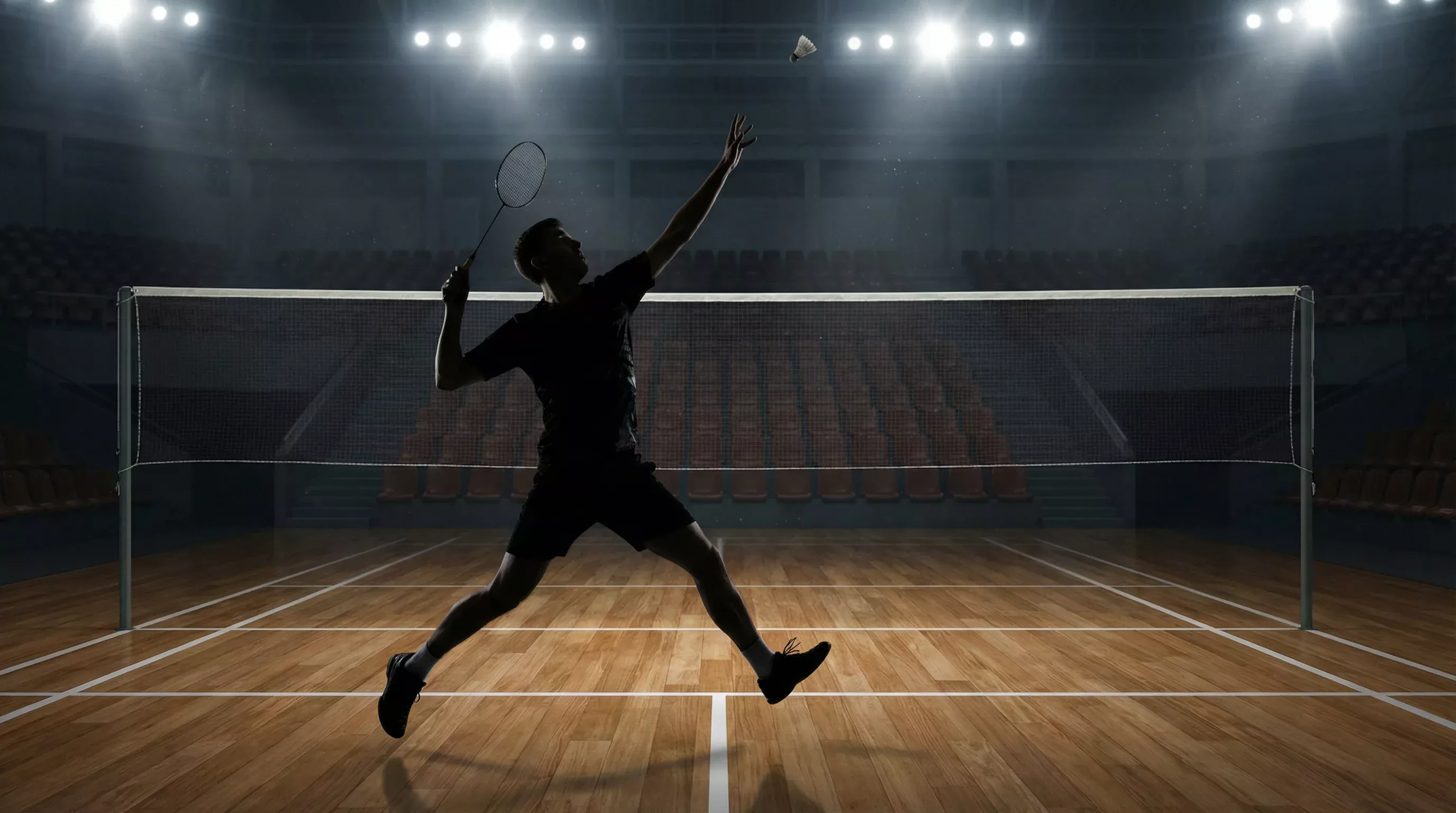 Badminton-Spieler streckt sich nach einem hohen Federball auf dem Court