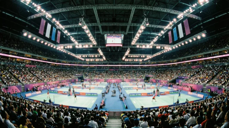 Blick in eine große Badminton-Turnierhalle mit mehreren Spielfeldern
